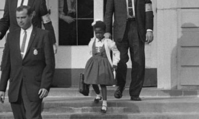 Des policiers fédéraux escortent Ruby Bridges, alors âgée de six ans, face à une foule raciste opposée à son entrée dans une école blanche, le 14 novembre 1960. © Anonymous/AP/SIPA